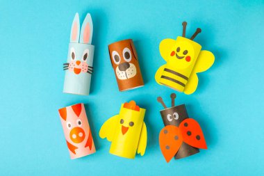 Renkli arka planda tuvalet kağıdı işçiliği. Tuvalet kağıdı rulosundan yapılmış çocuk el sanatları. DIY. El yapımı. Kağıt oyuncaklar. Origami hayvanları. Çocukların eğitici oyunları kavramı. Mesaj için yer. Boşluğu kopyala.