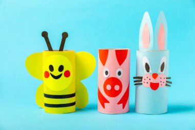 Renkli arka planda tuvalet kağıdı işçiliği. Tuvalet kağıdı rulosundan yapılmış çocuk el sanatları. DIY. El yapımı. Kağıt oyuncaklar. Origami hayvanları. Çocukların eğitici oyunları kavramı. Mesaj için yer. Boşluğu kopyala.