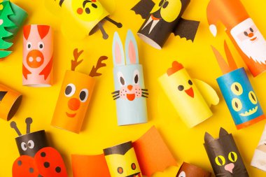 Renkli arka planda tuvalet kağıdı işçiliği. Tuvalet kağıdı rulosundan yapılmış çocuk el sanatları. DIY. El yapımı. Kağıt oyuncaklar. Origami hayvanları. Çocukların eğitici oyunları kavramı. Mesaj için yer. Boşluğu kopyala.