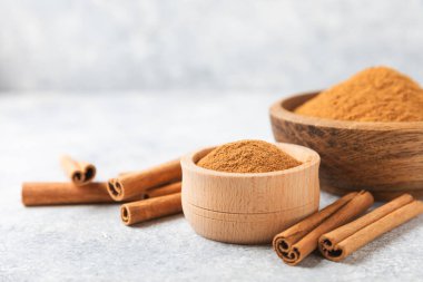 Ahşap kaplamalı bir kasede tarçın tozu. Fırın, tatlı ve içecekler için baharatlı baharat. Güzel kokulu tarçın. Tarçın çubuğu. Mesaj için yer. Boşluğu kopyala.