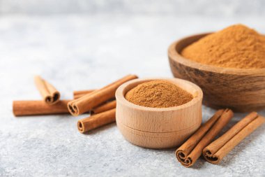 Ahşap kaplamalı bir kasede tarçın tozu. Fırın, tatlı ve içecekler için baharatlı baharat. Güzel kokulu tarçın. Tarçın çubuğu. Mesaj için yer. Boşluğu kopyala.