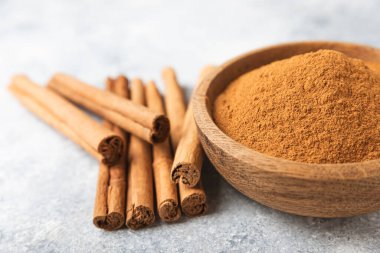 Ahşap kaplamalı bir kasede tarçın tozu. Fırın, tatlı ve içecekler için baharatlı baharat. Güzel kokulu tarçın. Tarçın çubuğu. Mesaj için yer. Boşluğu kopyala.