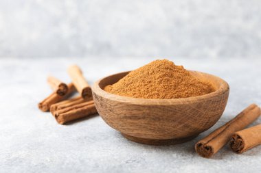 Ahşap kaplamalı bir kasede tarçın tozu. Fırın, tatlı ve içecekler için baharatlı baharat. Güzel kokulu tarçın. Tarçın çubuğu. Mesaj için yer. Boşluğu kopyala.