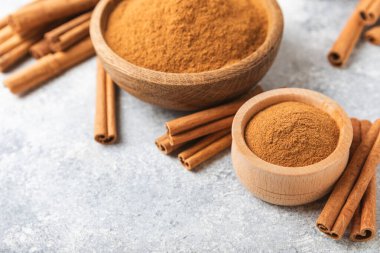 Ahşap kaplamalı bir kasede tarçın tozu. Fırın, tatlı ve içecekler için baharatlı baharat. Güzel kokulu tarçın. Tarçın çubuğu. Mesaj için yer. Boşluğu kopyala.