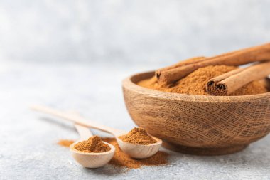 Ahşap kaplamalı bir kasede tarçın tozu. Fırın, tatlı ve içecekler için baharatlı baharat. Güzel kokulu tarçın. Tarçın çubuğu. Mesaj için yer. Boşluğu kopyala.