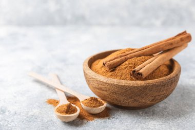 Ahşap kaplamalı bir kasede tarçın tozu. Fırın, tatlı ve içecekler için baharatlı baharat. Güzel kokulu tarçın. Tarçın çubuğu. Mesaj için yer. Boşluğu kopyala.