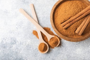 Ahşap kaplamalı bir kasede tarçın tozu. Fırın, tatlı ve içecekler için baharatlı baharat. Güzel kokulu tarçın. Tarçın çubuğu. Mesaj için yer. Boşluğu kopyala.