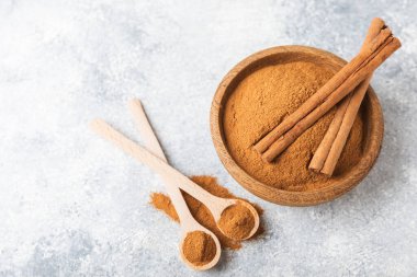 Ahşap kaplamalı bir kasede tarçın tozu. Fırın, tatlı ve içecekler için baharatlı baharat. Güzel kokulu tarçın. Tarçın çubuğu. Mesaj için yer. Boşluğu kopyala.