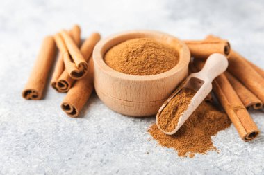 Ahşap kaplamalı bir kasede tarçın tozu. Fırın, tatlı ve içecekler için baharatlı baharat. Güzel kokulu tarçın. Tarçın çubuğu. Mesaj için yer. Boşluğu kopyala.