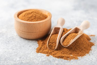 Ahşap kaplamalı bir kasede tarçın tozu. Fırın, tatlı ve içecekler için baharatlı baharat. Güzel kokulu tarçın. Tarçın çubuğu. Mesaj için yer. Boşluğu kopyala.