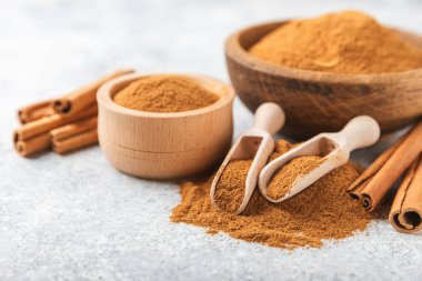 Ahşap kaplamalı bir kasede tarçın tozu. Fırın, tatlı ve içecekler için baharatlı baharat. Güzel kokulu tarçın. Tarçın çubuğu. Mesaj için yer. Boşluğu kopyala.