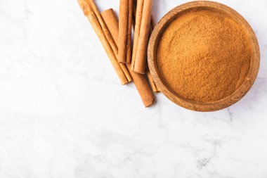 Ahşap kaplamalı bir kasede tarçın tozu. Fırın, tatlı ve içecekler için baharatlı baharat. Güzel kokulu tarçın. Tarçın çubuğu. Mesaj için yer. Boşluğu kopyala.