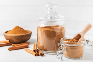 Ahşap kaplamalı bir kasede tarçın tozu. Fırın, tatlı ve içecekler için baharatlı baharat. Güzel kokulu tarçın. Tarçın çubuğu. Mesaj için yer. Boşluğu kopyala.