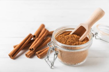 Ahşap kaplamalı bir kasede tarçın tozu. Fırın, tatlı ve içecekler için baharatlı baharat. Güzel kokulu tarçın. Tarçın çubuğu. Mesaj için yer. Boşluğu kopyala.