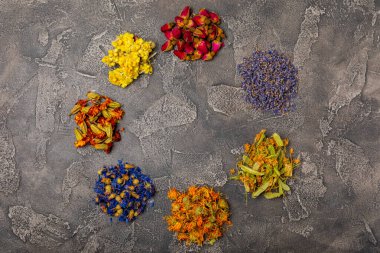 Ahşap bir zeminde kurumuş bitki ve çilek çayı. Şifalı bitkiler. Alternatif tıp konsepti. Linden, calendula, cornflowers, marigold, tansy, tea rose.