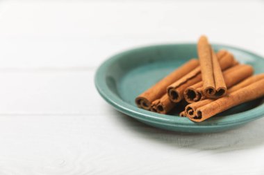 Tarçınlı çubuklar ahşap bir arka planda. Tarçınlı rulo. Fırın, tatlı ve içecekler için baharatlı baharat. Güzel kokulu tarçın. Tarçın tozu yakın plan. Mesaj için yer. Boşluğu kopyala