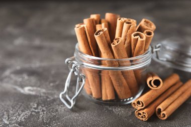 Tarçınlı çubuklar ahşap bir arka planda. Tarçınlı rulo. Fırın, tatlı ve içecekler için baharatlı baharat. Güzel kokulu tarçın. Tarçın tozu yakın plan. Mesaj için yer. Boşluğu kopyala