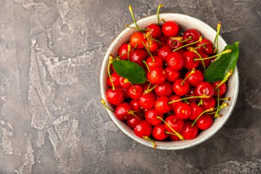 Kirazlar. Ahşap kaplamalı taze kirazlar ve yapraklar. Taze organik kiraz yığını. Böğürtlen ve meyve. Vejetaryen. Sağlıklı beslenme. Mesaj için yer. Boşluğu kopyala