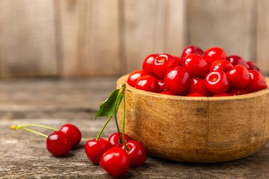 Kirazlar. Ahşap kaplamalı taze kirazlar ve yapraklar. Taze organik kiraz yığını. Böğürtlen ve meyve. Vejetaryen. Sağlıklı beslenme. Mesaj için yer. Boşluğu kopyala