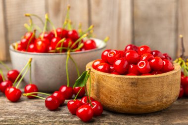 Kirazlar. Ahşap kaplamalı taze kirazlar ve yapraklar. Taze organik kiraz yığını. Böğürtlen ve meyve. Vejetaryen. Sağlıklı beslenme. Mesaj için yer. Boşluğu kopyala