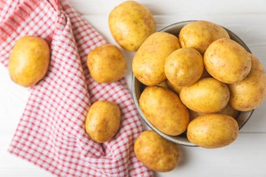 Genç patatesler Tahta zeminde taze patates. Hasat koleksiyonu. organik, taze kazılmış patatesler. Tarım geçmişi. Vejetaryen. Sebzeler. Mesajlar için yer. Boşluğu kopyala