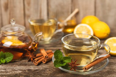 Tarçın sopasıyla kokulu sıcak çay ve ahşap bir arka planda anason. Ballı, limonlu, naneli ve elmalı bir fincan sıcak çay. Baharatlı baharatlı çay. Dokunulmazlık çayı. Sağlık kavramı. Boşluğu kopyala.