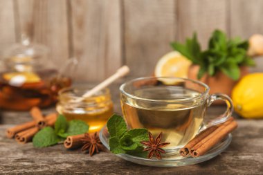 Tarçın sopasıyla kokulu sıcak çay ve ahşap bir arka planda anason. Ballı, limonlu, naneli ve elmalı bir fincan sıcak çay. Baharatlı baharatlı çay. Dokunulmazlık çayı. Sağlık kavramı. Boşluğu kopyala.