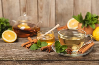 Tarçın sopasıyla kokulu sıcak çay ve ahşap bir arka planda anason. Ballı, limonlu, naneli ve elmalı bir fincan sıcak çay. Baharatlı baharatlı çay. Dokunulmazlık çayı. Sağlık kavramı. Boşluğu kopyala.