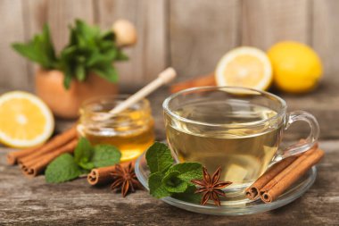 Tarçın sopasıyla kokulu sıcak çay ve ahşap bir arka planda anason. Ballı, limonlu, naneli ve elmalı bir fincan sıcak çay. Baharatlı baharatlı çay. Dokunulmazlık çayı. Sağlık kavramı. Boşluğu kopyala.