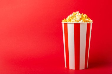 Patlamış mısır kutusu. Kırmızı ve beyaz çizgili patlamış mısır kovaları. Sinema ve eğlence anlayışı. Patlamış mısırla film gecesi. Peynirli patlamış mısır. Lezzetli aperatif, aperatif. Metin için yer.