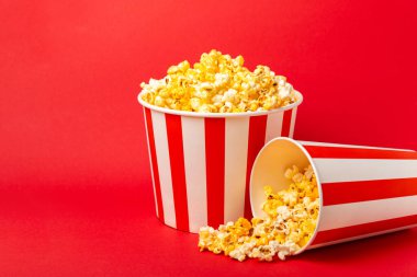 Patlamış mısır kutusu. Kırmızı ve beyaz çizgili patlamış mısır kovaları. Sinema ve eğlence anlayışı. Patlamış mısırla film gecesi. Peynirli patlamış mısır. Lezzetli aperatif, aperatif. Metin için yer.