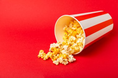 Patlamış mısır kutusu. Kırmızı ve beyaz çizgili patlamış mısır kovaları. Sinema ve eğlence anlayışı. Patlamış mısırla film gecesi. Peynirli patlamış mısır. Lezzetli aperatif, aperatif. Metin için yer.