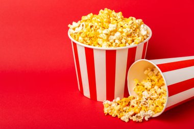 Patlamış mısır kutusu. Kırmızı ve beyaz çizgili patlamış mısır kovaları. Sinema ve eğlence anlayışı. Patlamış mısırla film gecesi. Peynirli patlamış mısır. Lezzetli aperatif, aperatif. Metin için yer.