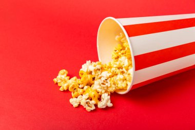 Patlamış mısır kutusu. Kırmızı ve beyaz çizgili patlamış mısır kovaları. Sinema ve eğlence anlayışı. Patlamış mısırla film gecesi. Peynirli patlamış mısır. Lezzetli aperatif, aperatif. Metin için yer.