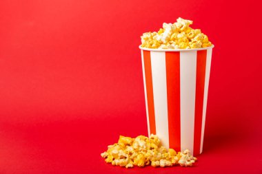 Patlamış mısır kutusu. Kırmızı ve beyaz çizgili patlamış mısır kovaları. Sinema ve eğlence anlayışı. Patlamış mısırla film gecesi. Peynirli patlamış mısır. Lezzetli aperatif, aperatif. Metin için yer.