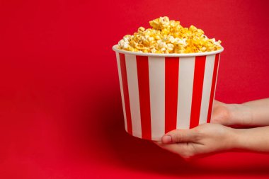 Patlamış mısır kutusu. Kırmızı ve beyaz çizgili patlamış mısır kovaları. Sinema ve eğlence anlayışı. Patlamış mısırla film gecesi. Peynirli patlamış mısır. Lezzetli aperatif, aperatif. Metin için yer.