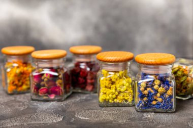 Ahşap arka planda kurumuş bitki ve böğürtlen çayı çeşitleri. Çay partisi konsepti. Şifalı bitkiler. Şifalı bitkiler. Alternatif ilaç. Linden, Calendula, Cornflowers, marigold, tansy, çay gülü..