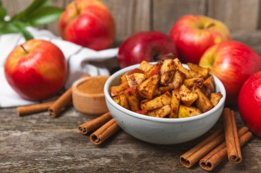 Tarçınlı elmalar ahşap kaplamalı. Tarçın çubukları ve yıldız anason ile kokulu kırmızı elmalar. Baharatlı elma dilimleri. Mesaj için yer. Uzayı kopyala Hasat. Meyveler.