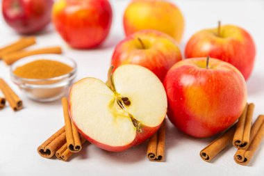 Tarçınlı elmalar ahşap kaplamalı. Tarçın çubukları ve yıldız anason ile kokulu kırmızı elmalar. Baharatlı elma dilimleri. Mesaj için yer. Uzayı kopyala Hasat. Meyveler.