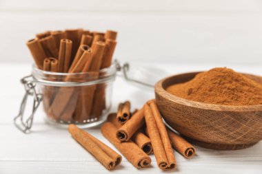 Tarçınlı çubuklar ahşap bir arka planda. Tarçınlı rulo. Fırın, tatlı ve içecekler için baharatlı baharat. Güzel kokulu tarçın. Tarçın tozu yakın plan. Mesaj için yer. Boşluğu kopyala