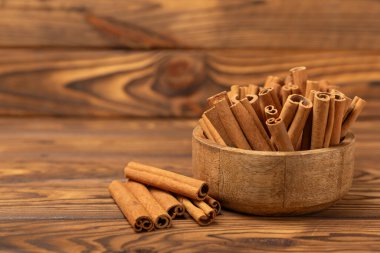 Tarçınlı çubuklar ahşap bir arka planda. Tarçınlı rulo. Fırın, tatlı ve içecekler için baharatlı baharat. Güzel kokulu tarçın. Tarçın tozu yakın plan. Mesaj için yer. Boşluğu kopyala