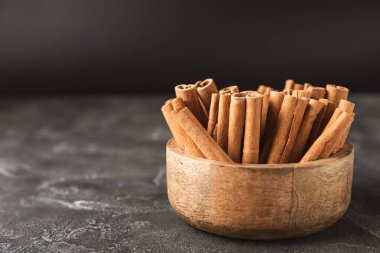 Tarçınlı çubuklar ahşap bir arka planda. Tarçınlı rulo. Fırın, tatlı ve içecekler için baharatlı baharat. Güzel kokulu tarçın. Tarçın tozu yakın plan. Mesaj için yer. Boşluğu kopyala