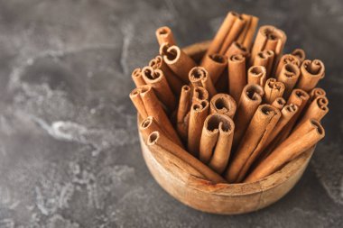 Tarçınlı çubuklar ahşap bir arka planda. Tarçınlı rulo. Fırın, tatlı ve içecekler için baharatlı baharat. Güzel kokulu tarçın. Tarçın tozu yakın plan. Mesaj için yer. Boşluğu kopyala