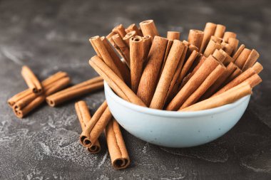 Tarçınlı çubuklar ahşap bir arka planda. Tarçınlı rulo. Fırın, tatlı ve içecekler için baharatlı baharat. Güzel kokulu tarçın. Tarçın tozu yakın plan. Mesaj için yer. Boşluğu kopyala