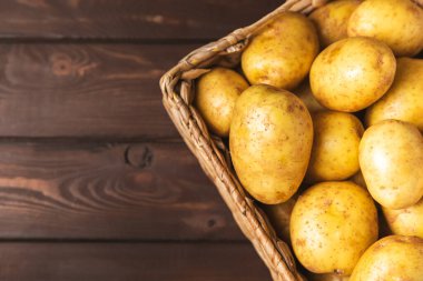 Genç patatesler Tahta zeminde taze patates. Hasat koleksiyonu. organik, taze kazılmış patatesler. Tarım geçmişi. Vejetaryen. Sebzeler. Mesajlar için yer. Boşluğu kopyala