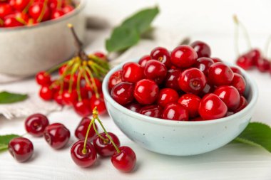 Kirazlar. Ahşap kaplamalı taze kirazlar ve yapraklar. Taze organik kiraz yığını. Böğürtlen ve meyve. Vejetaryen. Sağlıklı beslenme. Mesaj için yer. Boşluğu kopyala