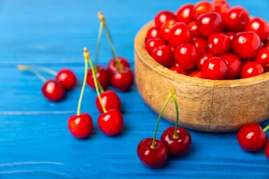 Kirazlar. Ahşap kaplamalı taze kirazlar ve yapraklar. Taze organik kiraz yığını. Böğürtlen ve meyve. Vejetaryen. Sağlıklı beslenme. Mesaj için yer. Boşluğu kopyala