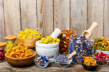 Ahşap arka planda kurumuş bitki ve böğürtlen çayı çeşitleri. Çay partisi konsepti. Şifalı bitkiler. Şifalı bitkiler. Alternatif ilaç. Linden, Calendula, Cornflowers, marigold, tansy, çay gülü..