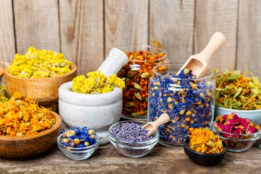 Ahşap arka planda kurumuş bitki ve böğürtlen çayı çeşitleri. Çay partisi konsepti. Şifalı bitkiler. Şifalı bitkiler. Alternatif ilaç. Linden, Calendula, Cornflowers, marigold, tansy, çay gülü..