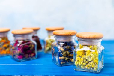 Ahşap arka planda kurumuş bitki ve böğürtlen çayı çeşitleri. Çay partisi konsepti. Şifalı bitkiler. Şifalı bitkiler. Alternatif ilaç. Linden, Calendula, Cornflowers, marigold, tansy, çay gülü..